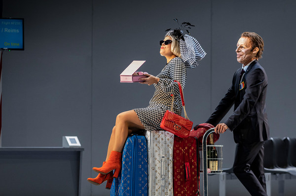 Szene aus "Il viaggo a Reims": Sängerin sitz auf Koffern auf einem Gepäckwagen, der von einem Sänger geschoben wird