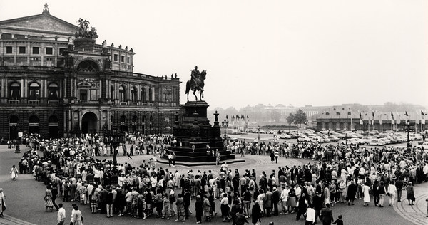 Zahlreiche Menschen versammeln sich auf dem Theaterplatz vor der Semperoper rund um die König-Johann-Statue, einen Reiter auf einem Sockel
