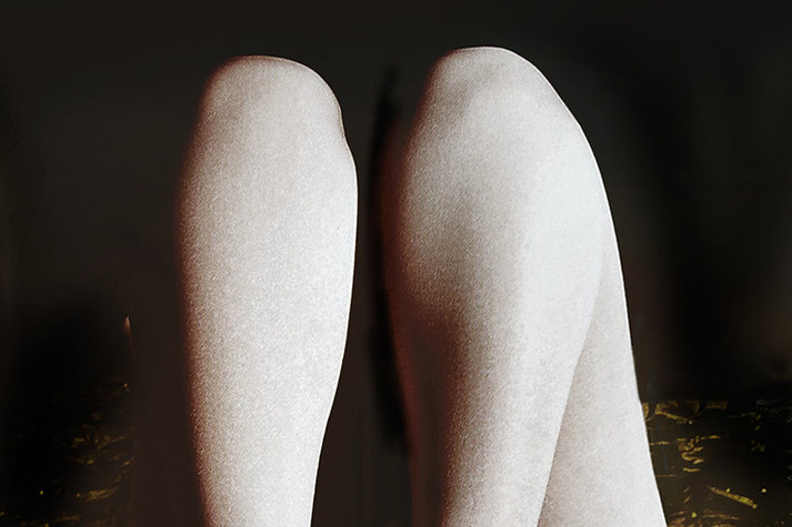 Die Fotoaufnahme der Künstlerin Rosemarie Trockel zeigt zwei Beine mit weißer Haut vor schwarzem Hintergrund.