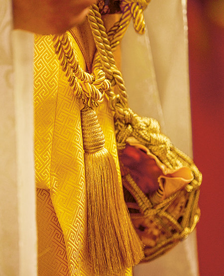 Nahaufnahme einer goldenen Kordel und eines gold-rotes Säckchens an einem Kimono, einem Kostüm aus der Oper »Madama Butterfly«  