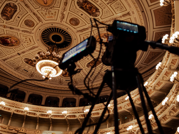 Zuschauerraum der Semperoper mit Kronleuchter und Filmkamera im Vordergrund