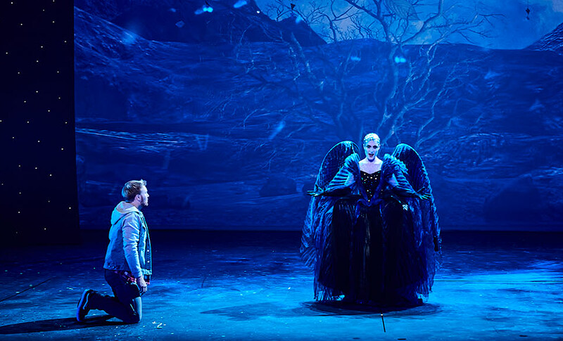 Szene aus "Die Zauberflöte": Sängerin steht mittig auf der Bühne, ein Sänger kniet links neben ihr